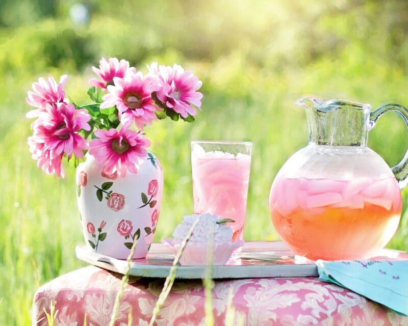 Flowers and iced drink on table.